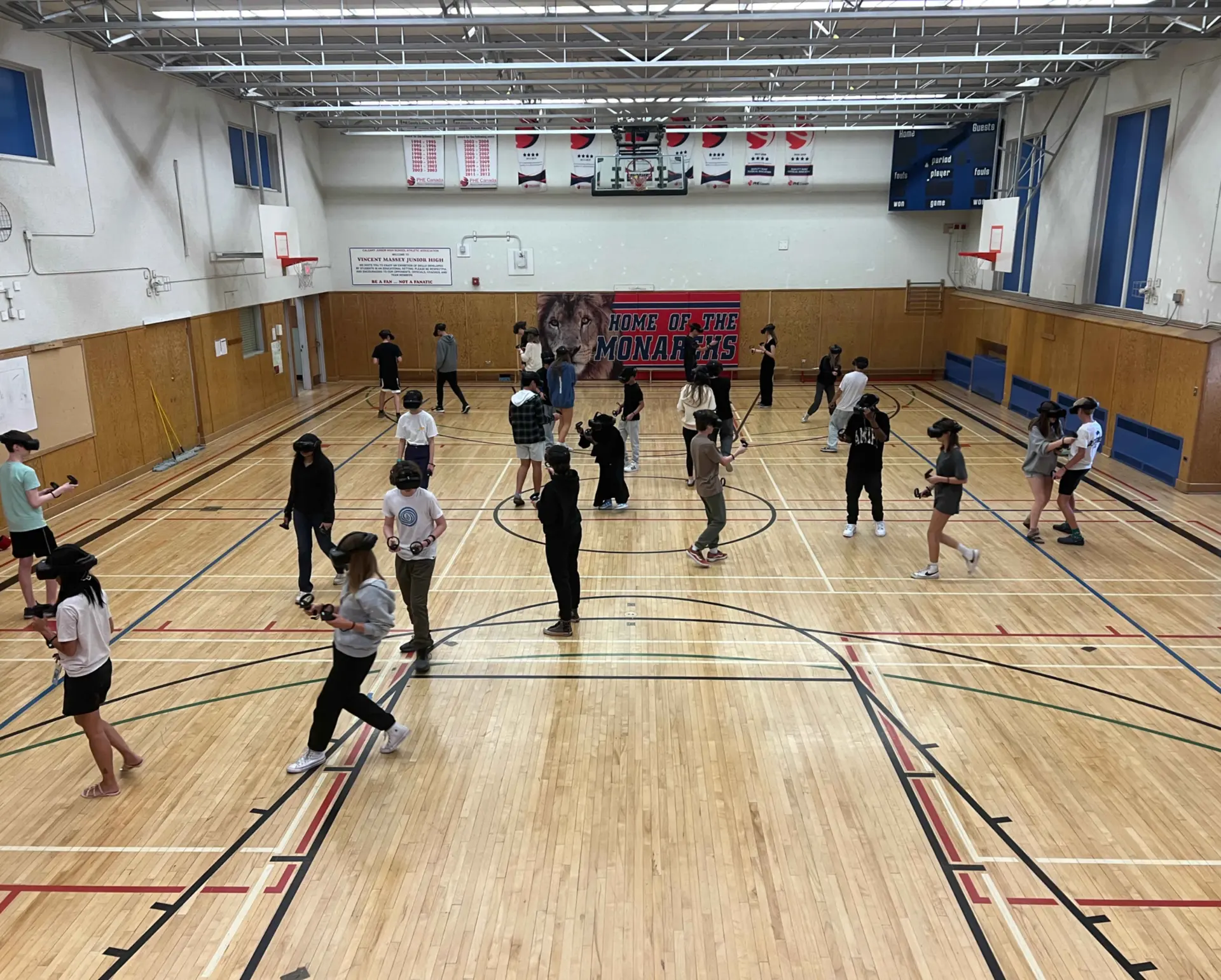 A class sharing a free-roam VR experience in a school gym